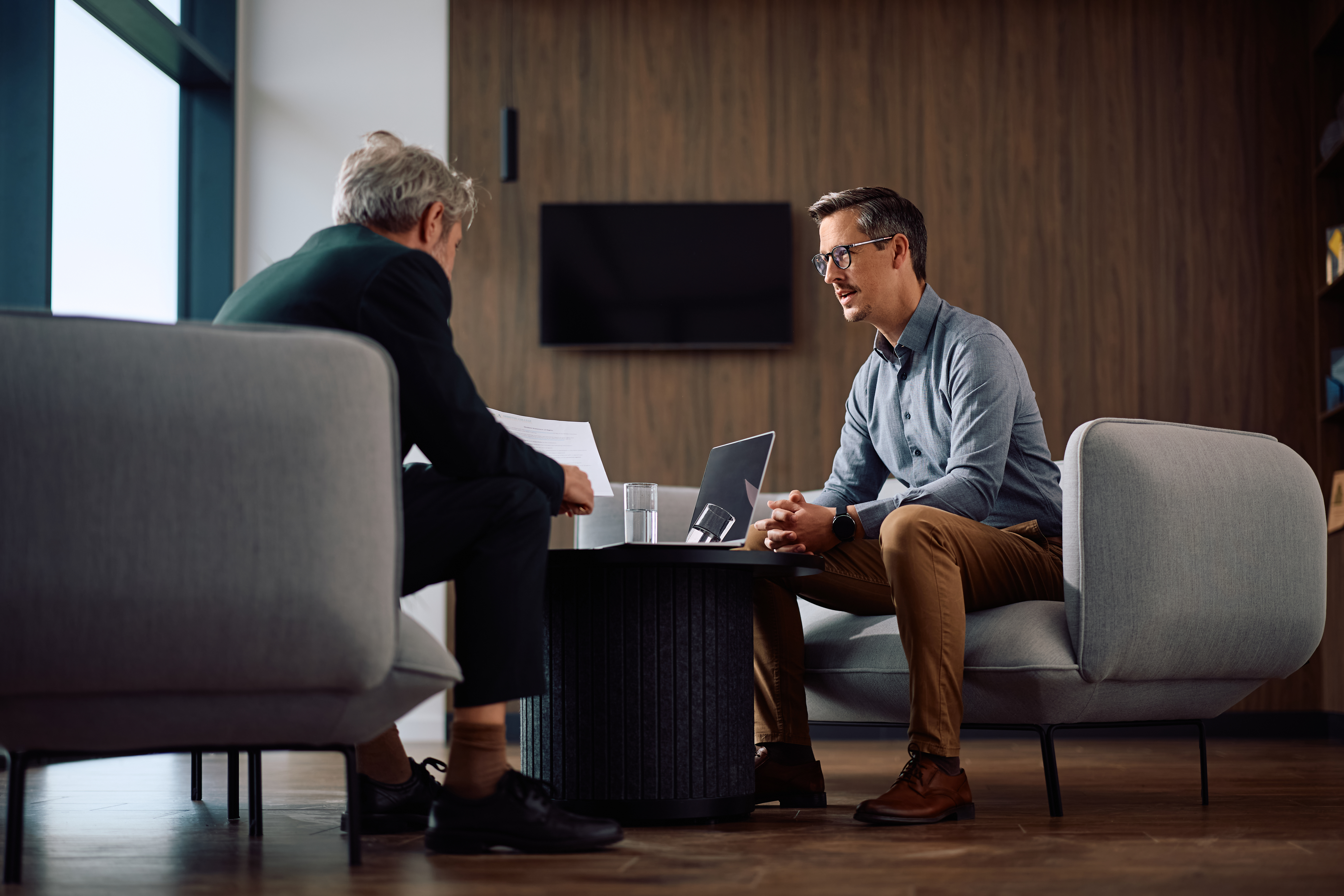 Male entrepreneur and his CEO analyzing business reports during a meeting in the office.